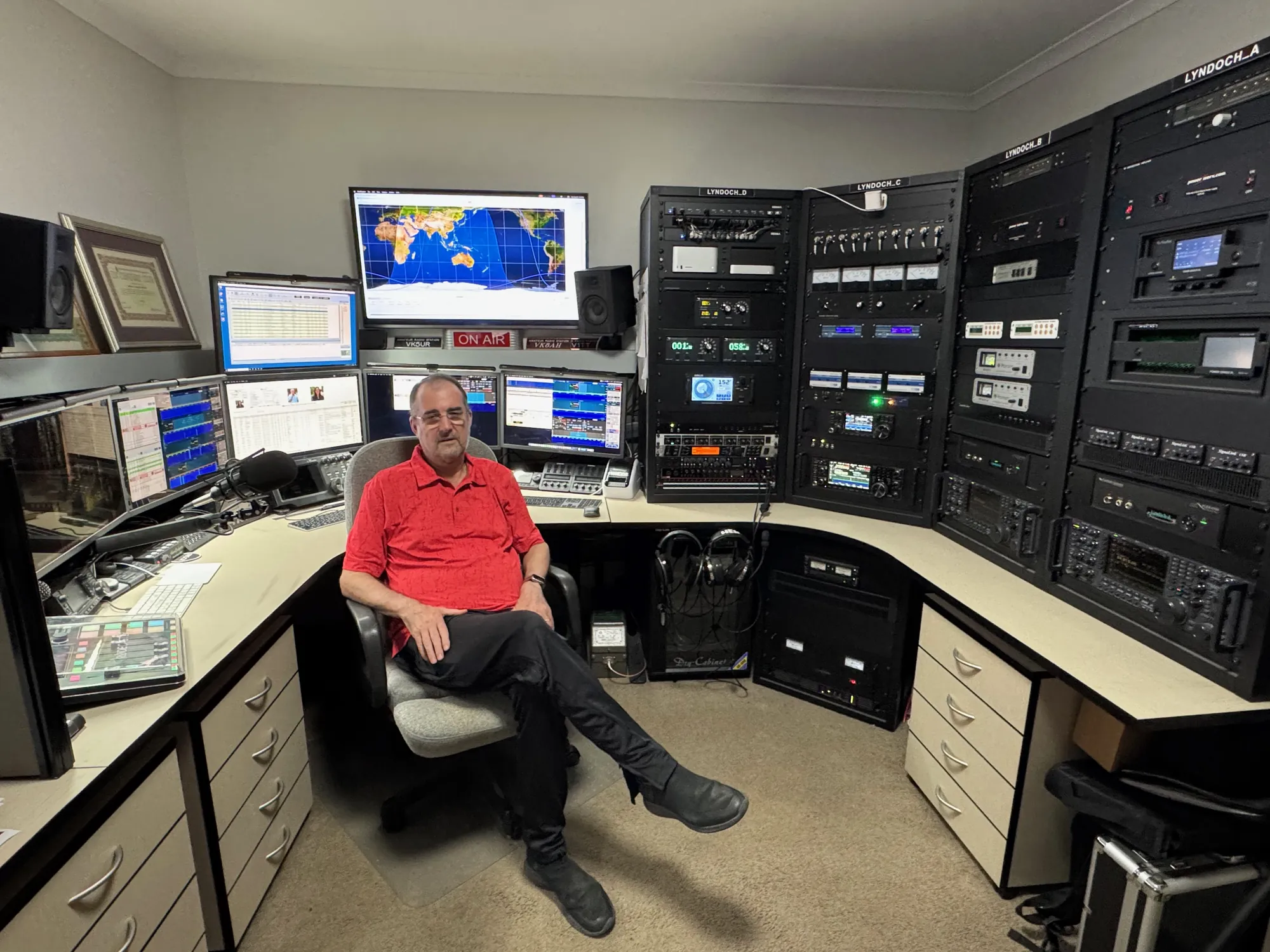 Andrew Hodges, VK5UR, seated at the operating position with equipment racks Lyndoch A to D